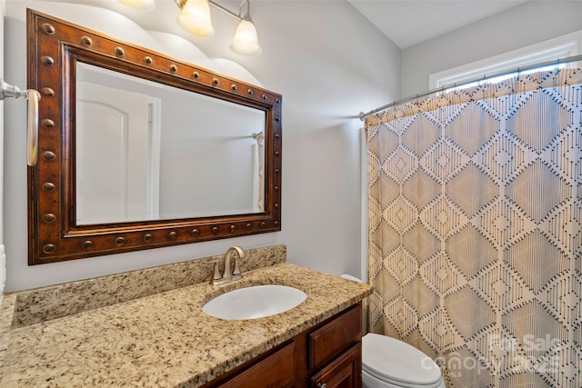 full bathroom with curtained shower, vanity, and toilet