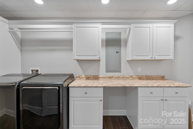 washroom with cabinet space, electric panel, baseboards, dark wood-type flooring, and washing machine and clothes dryer