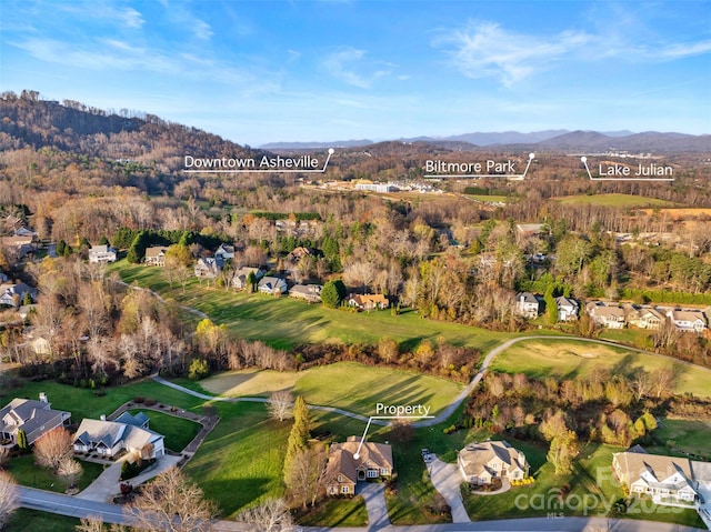 birds eye view of property featuring a residential view, a mountain view, and a view of trees