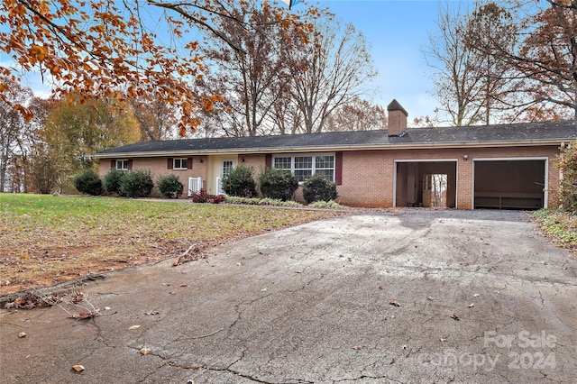 single story home with a front yard and a garage