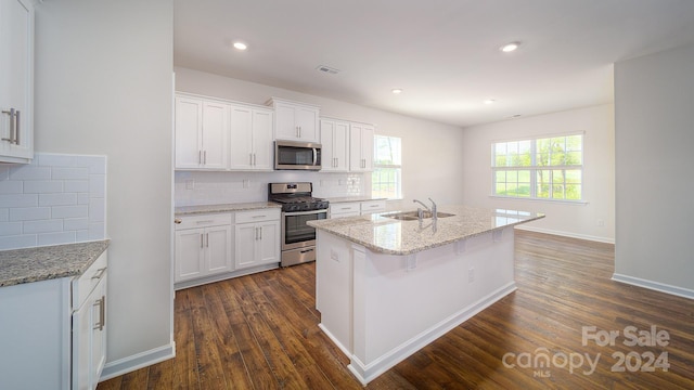 kitchen with white cabinets, dark hardwood / wood-style flooring, stainless steel appliances, and tasteful backsplash