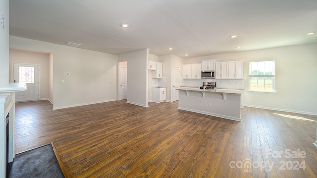 unfurnished living room with plenty of natural light and dark wood-type flooring