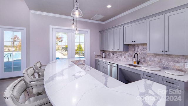 kitchen featuring a kitchen breakfast bar, stainless steel dishwasher, a healthy amount of sunlight, and sink