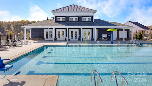 view of swimming pool featuring french doors and a patio