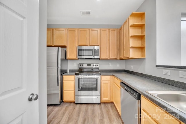 kitchen with sink, light wood-type flooring, light brown cabinetry, and appliances with stainless steel finishes