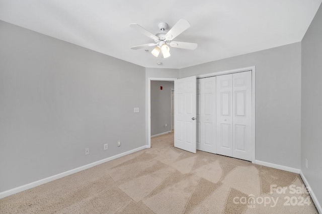 unfurnished bedroom with ceiling fan, a closet, and light colored carpet