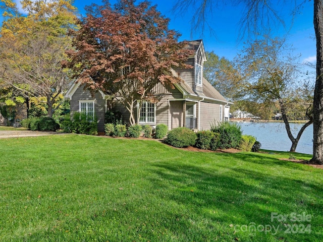 obstructed view of property with a front yard and a water view