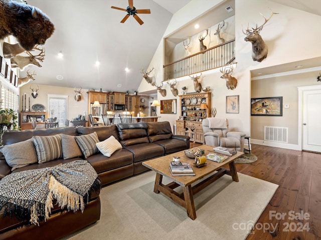 living room featuring hardwood / wood-style flooring, ceiling fan, and high vaulted ceiling