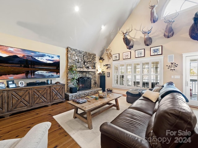 living room featuring hardwood / wood-style floors, a fireplace, and high vaulted ceiling