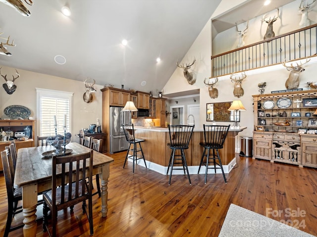 dining space featuring dark hardwood / wood-style floors and high vaulted ceiling