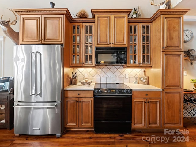 kitchen featuring tasteful backsplash, dark wood-type flooring, and black appliances