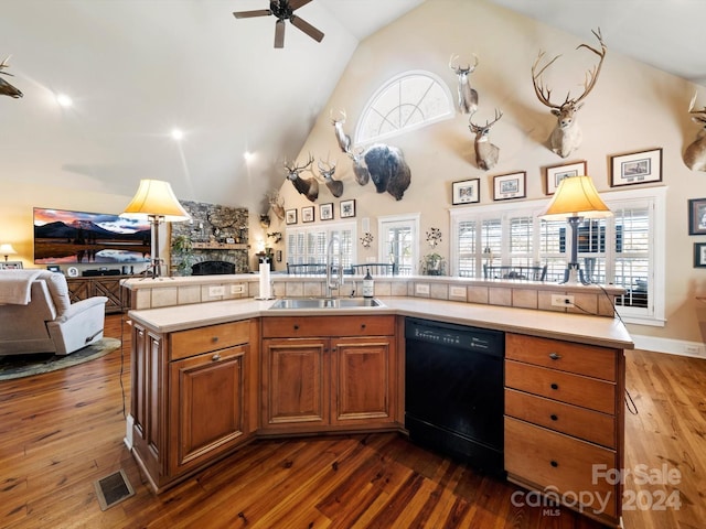 kitchen with black dishwasher, dark hardwood / wood-style floors, an island with sink, and sink