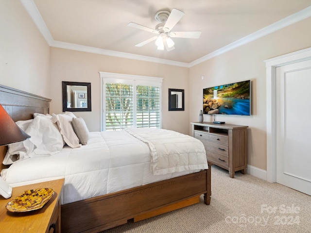 carpeted bedroom featuring ceiling fan and crown molding