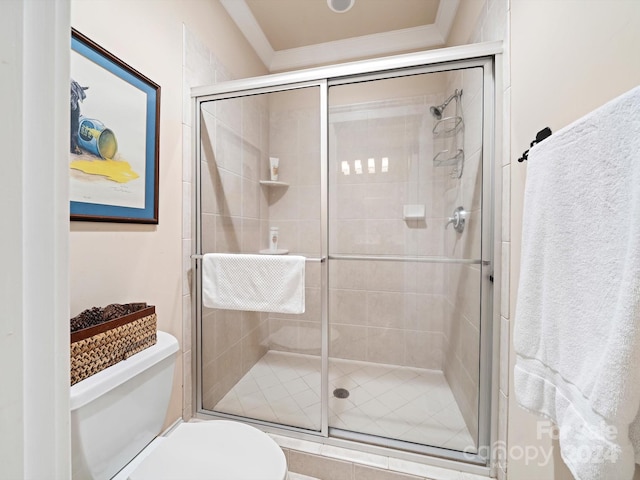 bathroom featuring toilet, a shower with door, and ornamental molding