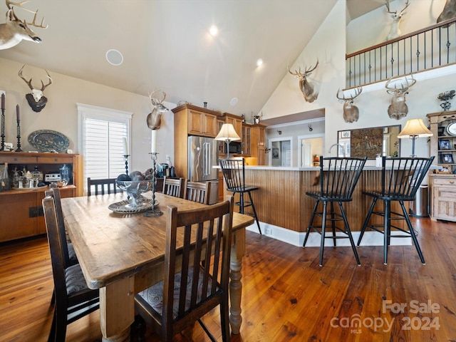 dining area featuring dark hardwood / wood-style flooring and high vaulted ceiling