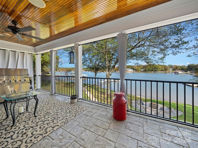 unfurnished sunroom with a water view, ceiling fan, and wood ceiling