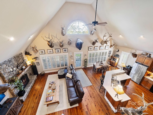 living room with a fireplace, high vaulted ceiling, and hardwood / wood-style flooring