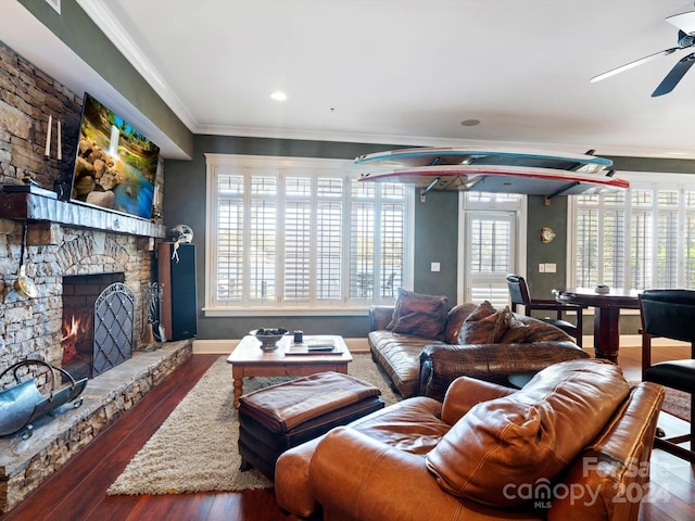 living room with a fireplace, dark hardwood / wood-style flooring, ceiling fan, and ornamental molding