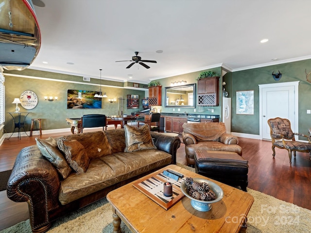 living room with hardwood / wood-style flooring, ceiling fan, crown molding, and sink