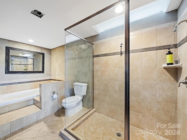 bathroom with tile patterned flooring, toilet, tile walls, and independent shower and bath