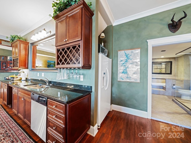 kitchen featuring dark hardwood / wood-style flooring, sink, dark stone countertops, dishwasher, and white fridge with ice dispenser