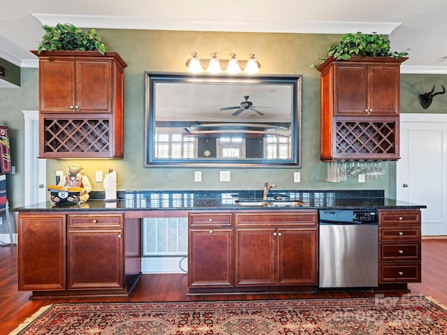 kitchen with stainless steel dishwasher, dark wood-type flooring, sink, crown molding, and dark stone countertops