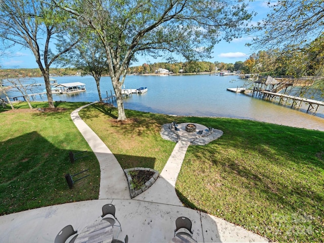 exterior space with a dock, a water view, and a fire pit