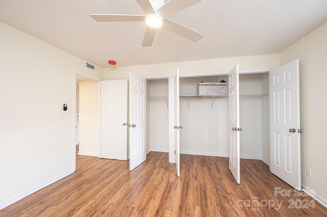 unfurnished bedroom featuring wood-type flooring, a textured ceiling, and ceiling fan