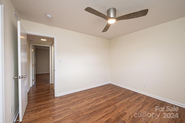 spare room featuring a textured ceiling, ceiling fan, and dark wood-type flooring