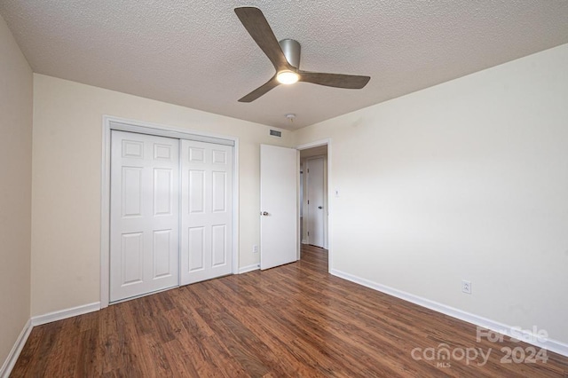 unfurnished bedroom featuring dark hardwood / wood-style floors, ceiling fan, a textured ceiling, and a closet