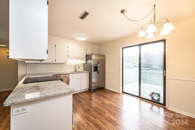 kitchen featuring hardwood / wood-style floors, decorative light fixtures, light stone counters, white cabinetry, and stainless steel appliances