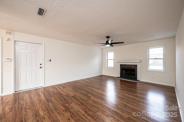 123 23rd St NW Unit E, Hickory, NC 28601 - unfurnished living room featuring ceiling fan, a textured ceiling, dark wood-style flooring, a fireplace with raised hearth, and baseboards