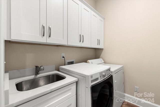 washroom with washer and clothes dryer, cabinets, and sink