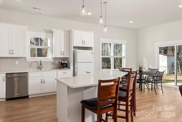 kitchen with dishwasher, white refrigerator, white cabinetry, and sink