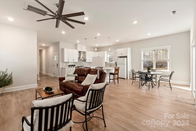 living room with ceiling fan and light hardwood / wood-style flooring