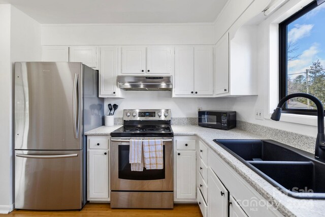 kitchen featuring white cabinets, stainless steel appliances, light hardwood / wood-style floors, and sink