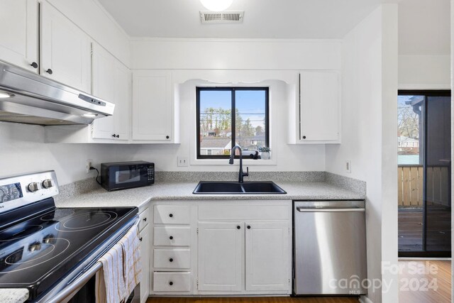 kitchen with hardwood / wood-style floors, white cabinets, sink, and appliances with stainless steel finishes