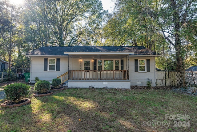 ranch-style home featuring a front lawn and covered porch