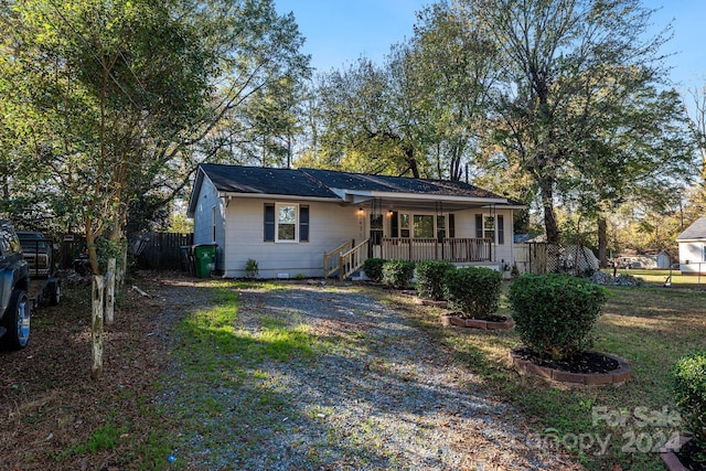 ranch-style house with a porch and a front yard