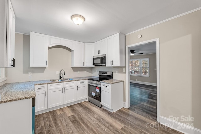 kitchen with white cabinets, sink, stainless steel appliances, and hardwood / wood-style flooring