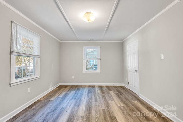 spare room featuring hardwood / wood-style floors and ornamental molding