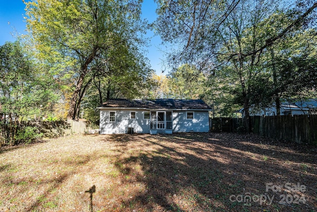 rear view of property featuring a yard