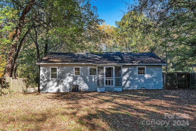 rear view of property featuring a lawn