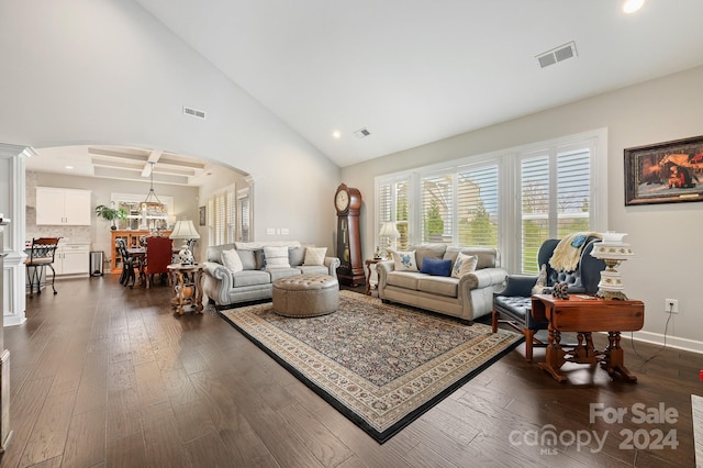 living room featuring dark wood-type flooring and high vaulted ceiling