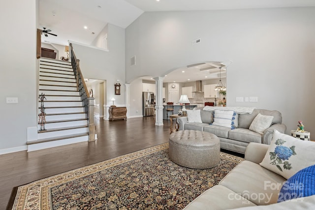 living room with high vaulted ceiling, ceiling fan, and dark wood-type flooring