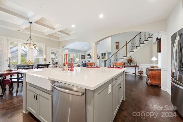 kitchen featuring appliances with stainless steel finishes, dark hardwood / wood-style flooring, plenty of natural light, and a kitchen island with sink