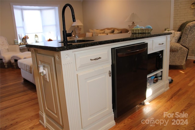 kitchen featuring sink, dishwasher, white cabinets, and light wood-type flooring