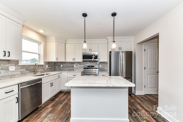 kitchen featuring white cabinetry, sink, a center island, dark hardwood / wood-style flooring, and appliances with stainless steel finishes