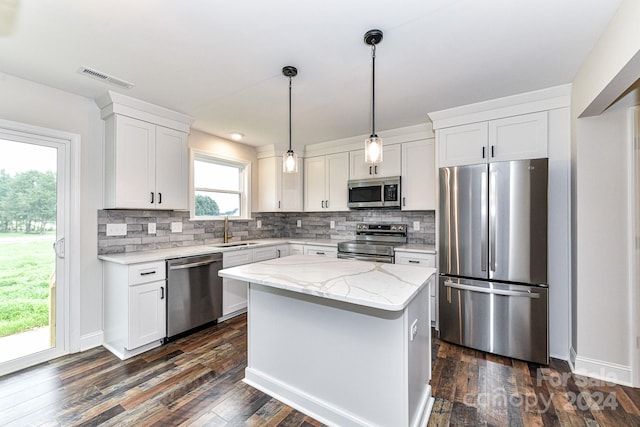 kitchen featuring pendant lighting, dark hardwood / wood-style floors, appliances with stainless steel finishes, a kitchen island, and white cabinetry