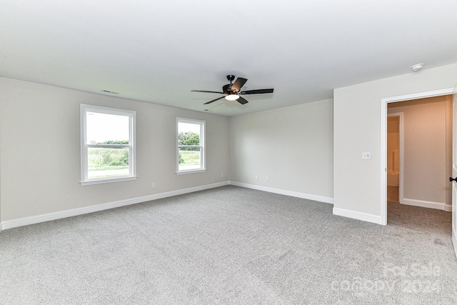 carpeted spare room with ceiling fan